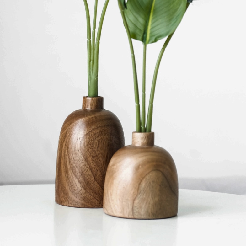 Two wooden vases with plants in them.