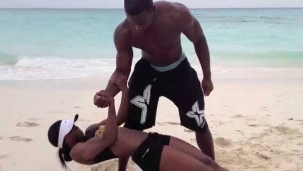 A black man and a woman on the beach.