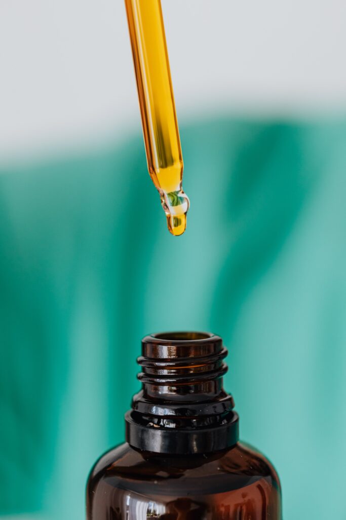 A drop of cbd oil is being poured into a bottle.