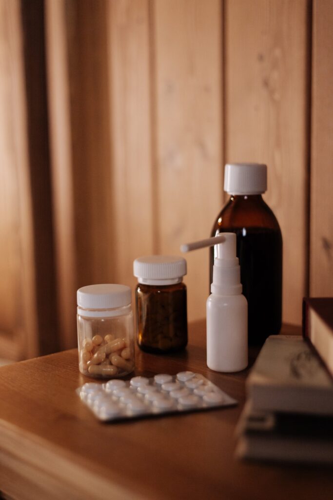 A bottle of medicine, pills, and a book on a table.